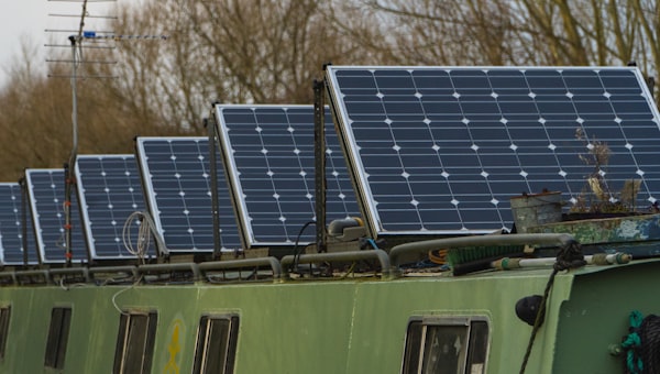 Blue solar panels on green and white bus